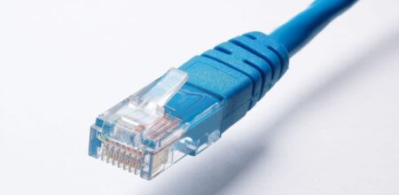 Lähikuva sinisestä Ethernet-verkkokaapelista ja RJ45-liittimestä