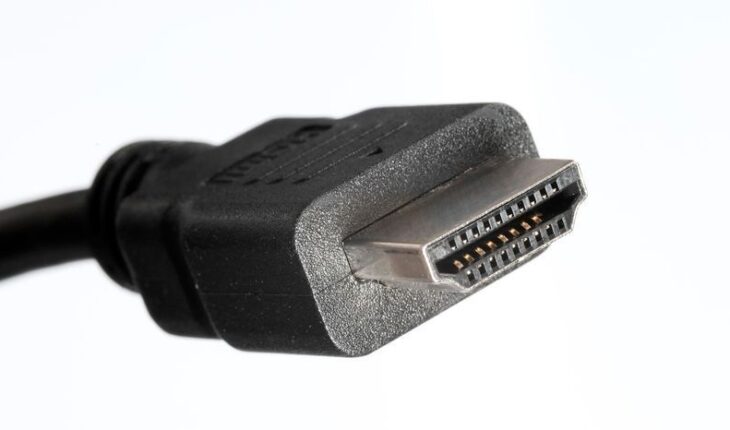 Lähikuva mustasta HDMI-kaapelin urosliittimestä valkoisella taustalla